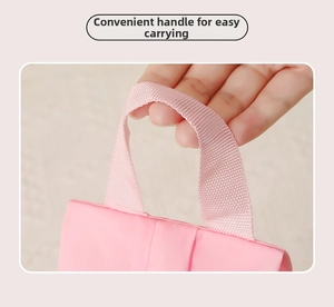 Dettaglio di una borsa rosa con manico in fettuccia rinforzata per un facile trasporto in viaggio