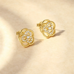 Macro shot of S925 silver gold-plated hollow petal stud earrings with white zircon accents