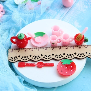 Miniature resin strawberry teapot and teacup set displayed with a ruler for size reference