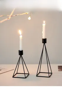 Detail of Nordic black metal geometric pyramid candle holders in a cozy home setting