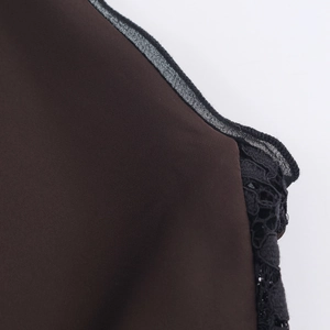 Detailed macro view of dark brown satin fabric with delicate black floral lace stitching