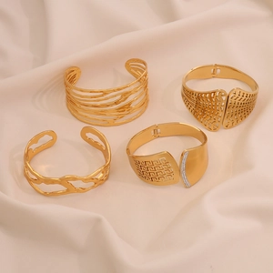 Bracelets joncs dorés ajourés aux textures florales et géométriques sur soie