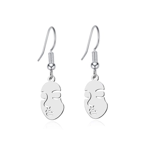 Macro detail of silver abstract face hollow earrings with polished metal reflection