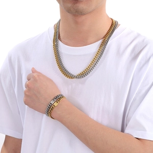 Detail view of two-tone gold and silver Cuban link necklace and bracelet set on a model