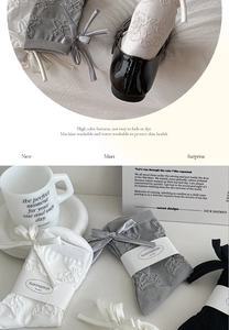 Detail of grey knitted socks with bow and textured bear pattern in various colors
