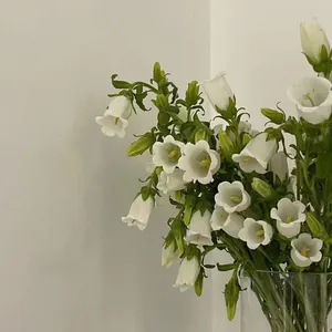 Close-up of white bellflowers in a glass vase with a fresh floral pattern cotton bag
