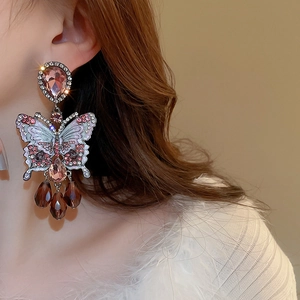 Close-up of vintage butterfly earrings with crystals and hanging beaded tassels on a model