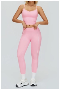 Dettaglio del set yoga rosa con crop top a V e leggings con cuciture a contrasto bianche