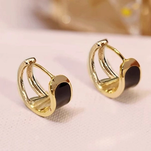 Elegant gold U-shape hoop earrings with black enamel inlay on textured card background