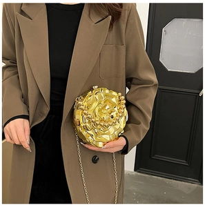 Close-up of golden 3D rose-shaped metallic evening clutch with crossbody chain strap