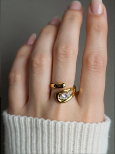 Close-up of a gold adjustable ring with a marquise-cut zircon on a model's finger
