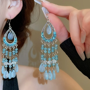 Detail of bohemian sky blue tassel earrings featuring vintage silver frames and crystal beads