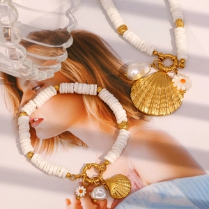 Détail de l'ensemble collier et bracelet en nacre et perles baroques sur un magazine