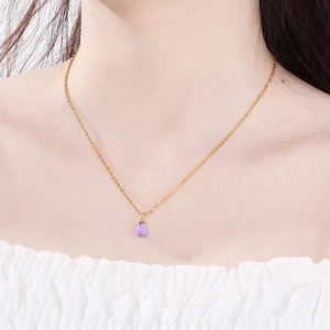 Dettaglio di una catenina d'oro con ciondolo a forma di melanzana in smalto viola