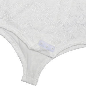 Detailed macro view of white lace bodysuit crotch area with three snap button closures