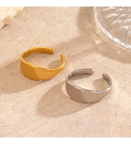 Minimalist wide open ring in gold and silver finish on a textured stone background