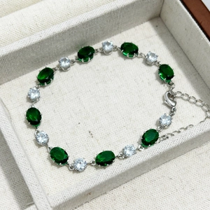Gros plan détaillé du bracelet en zircon émeraude ovale avec chaîne argentée et fermoir