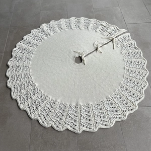Detail of knitted Christmas tree skirt featuring scalloped edges and hollow wave patterns