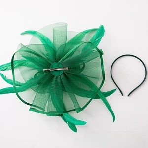 Detail view of emerald green mesh fascinator set with feathers and hair clip