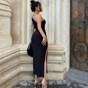 Detail of elegant black one-shoulder slim dress with high side slit and soft texture