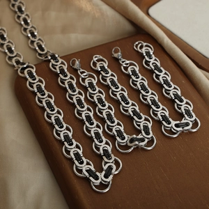 Classic Byzantine style silver and black titanium steel chain jewelry set on wood