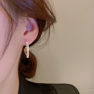 Macro detail of gold plated heart hoop earrings with sparkling cubic zirconia stones