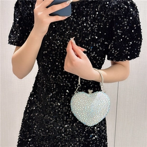 Detailed macro view of heart-shaped evening clutch with sparkling rhinestones and metal handle