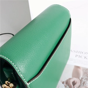 Dettaglio della borsa in pelle verde con cuciture bianche fini e trama di lusso