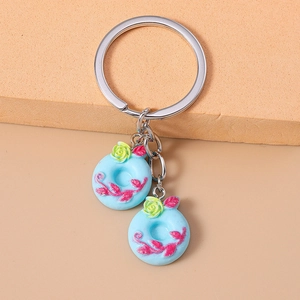 Close-up of blue donut keychains with pink floral patterns and yellow flower details