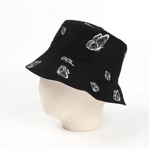 Détail d'un chapeau bob noir en coton avec des motifs de papillons blancs