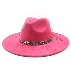 Detail of fuchsia suede cowboy hat featuring woven band and evil eye metal ornament