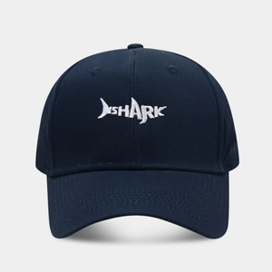 Detailansicht der weißen Haifisch-Stickerei auf einer dunkelblauen Baumwollkappe