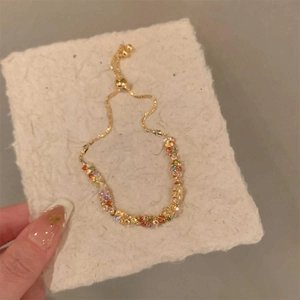 Dettaglio del bracciale dorato regolabile con cristalli sfaccettati dai colori vivaci