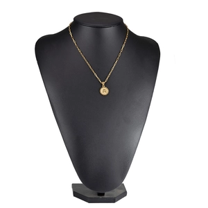 Close-up of golden letter A pendant with paperclip chain on black neck display