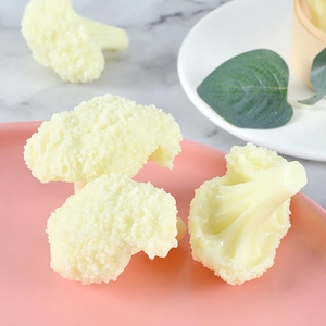 Realistic artificial cauliflower model in pink plate with natural decorative elements