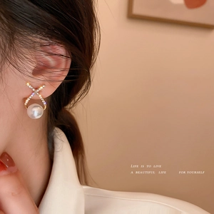 Elegant gold crossover stud earrings with sparkling crystals and large white pearls