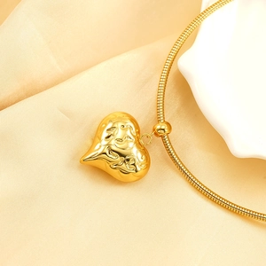 Collier élégant avec pendentif cœur doré et chaîne serpent sur fond de soie