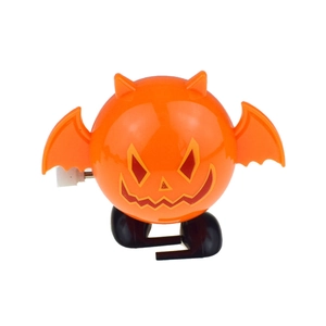 Detail of orange clockwork bat toy with pumpkin face and black wings for Halloween