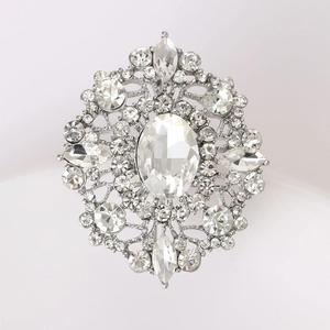 Macro shot of silver vintage brooch with oval rhinestone and intricate cutout details