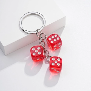 Detail of red transparent dice charms on silver metal keyring with white background