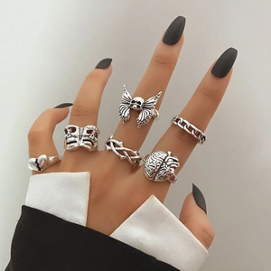 Gothic punk silver ring set featuring skull butterfly and heart designs on model hand