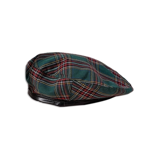 Détail de la casquette plate écossaise montrant le tissu en laine verte et le bord en cuir