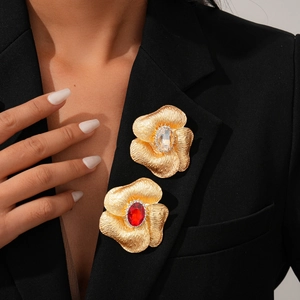 Elegant gold flower brooches with oval crystals and diamonds on black blazer lapel