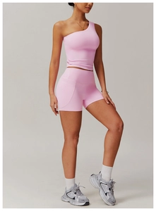 Détail de l'ensemble de yoga rose avec haut court à une épaule et short de fitness