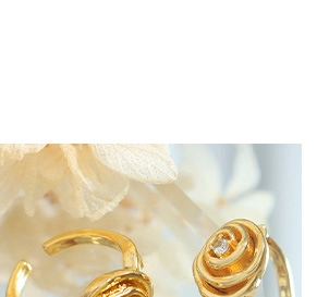 Macro shot of gold-plated rose flower rings with small gemstone inlay for women