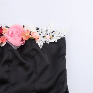 Sexy schwarzes Tube-Top mit 3D-Blumenakzenten in Pink und Orange auf weißem Grund
