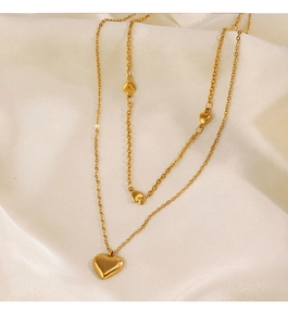 Vue détaillée du collier double rang avec cœurs dorés sur un fond en soie blanche