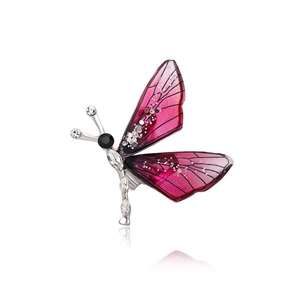 Macro detail of a gradient pink and purple enamel butterfly brooch with sparkling crystals