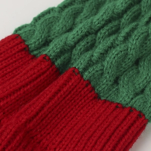Dettaglio della trama in maglia a coste rossa e trecce verdi sul berretto natalizio per bambini