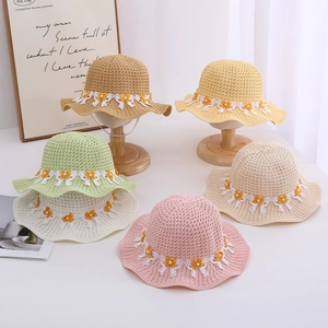 Detail of children's straw hats with wavy edges and lace floral decorations in six colors